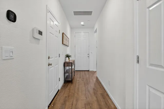 a view of a hallway with wooden floor