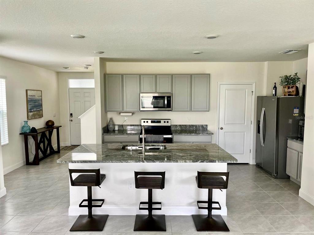 2771 Common Fig Run Wesley Chapel, FL 33543 - Photo 7 of 16 a kitchen with refrigerator and chairs