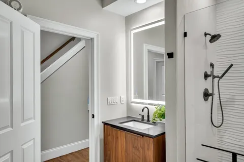 a bathroom with a granite countertop shower a mirror and a sink