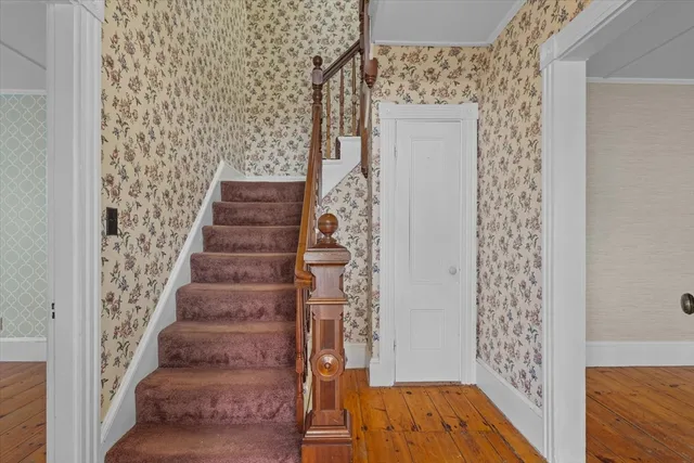 a view of a hallway with wooden floor and entryway
