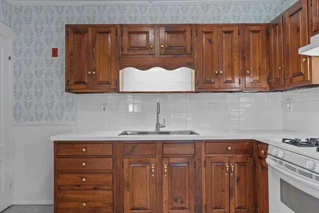 a kitchen with granite countertop wooden cabinets and a stove