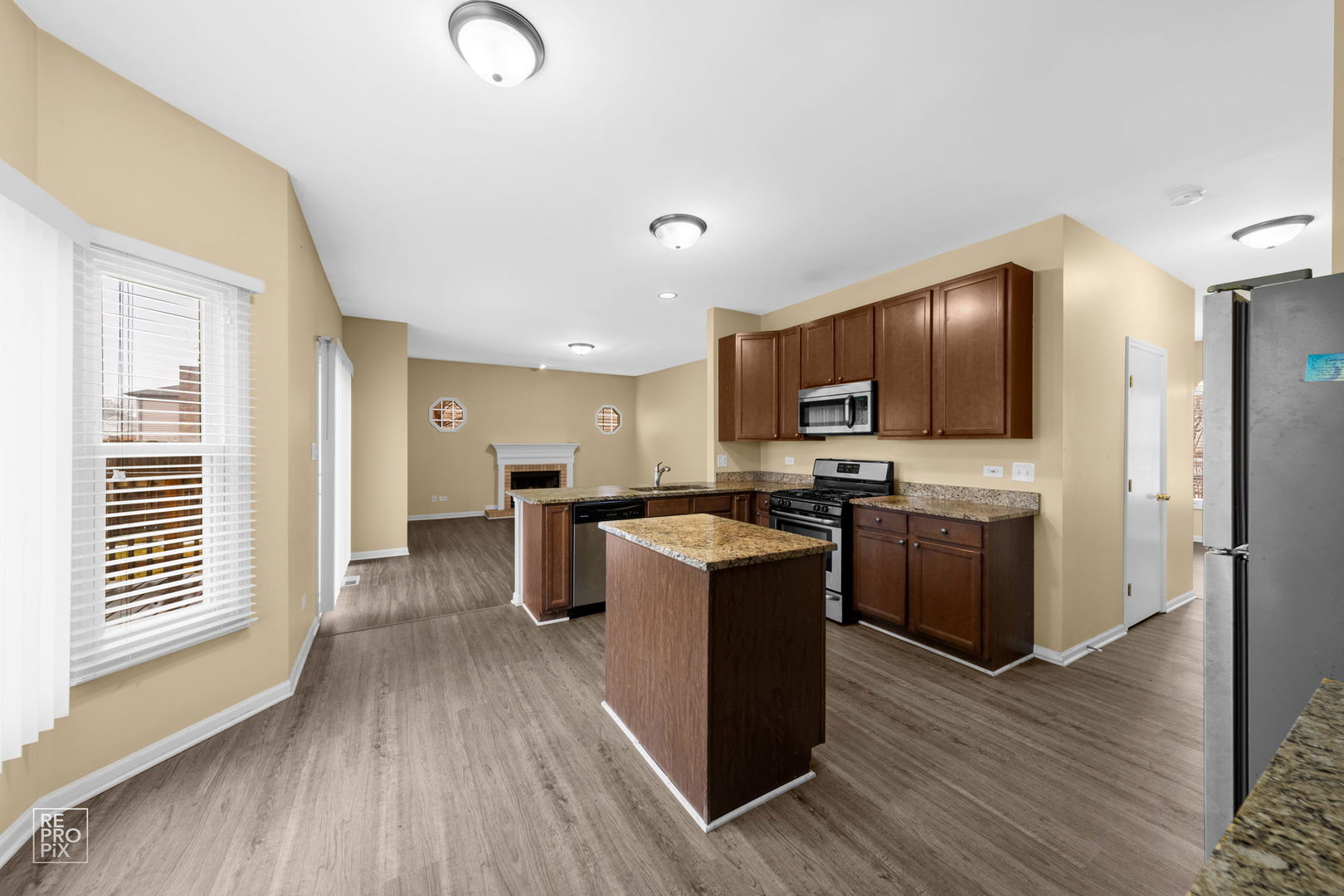 5519 Feather Creek Road Matteson, IL 60443 - Photo 11 of 26 a kitchen with stove a sink dishwasher a refrigerator and a microwave oven with wooden floor