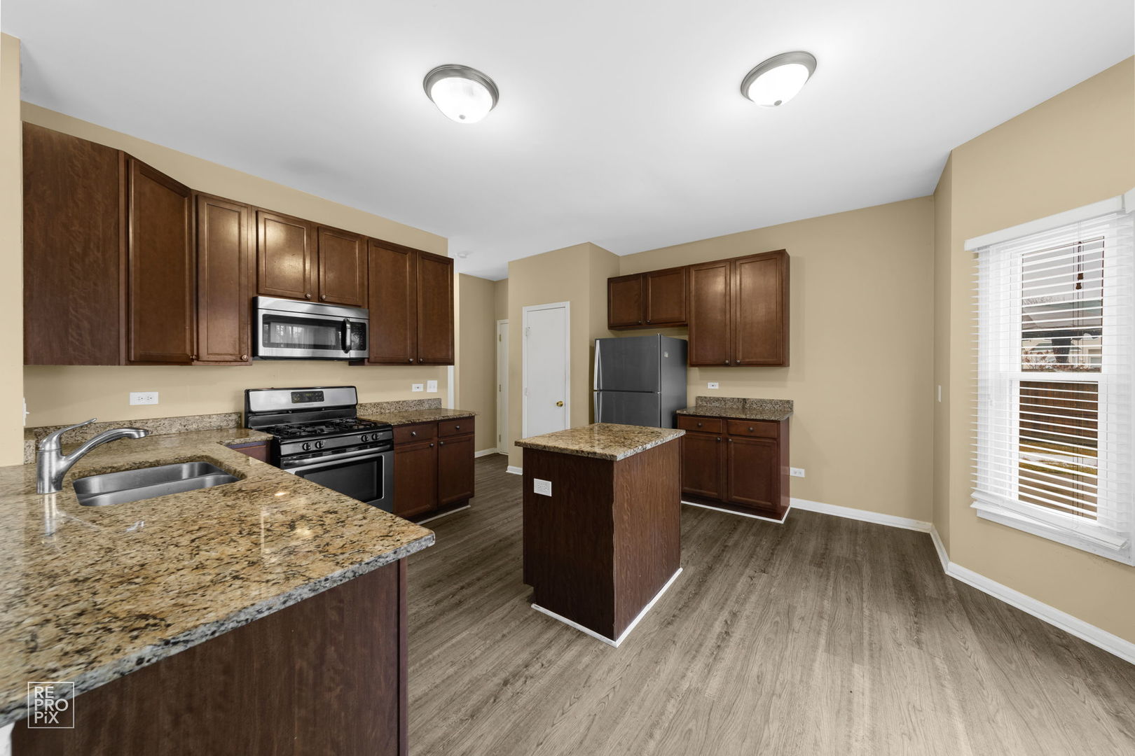 5519 Feather Creek Road Matteson, IL 60443 - Photo 13 of 26 a kitchen with granite countertop a refrigerator stove top oven and sink