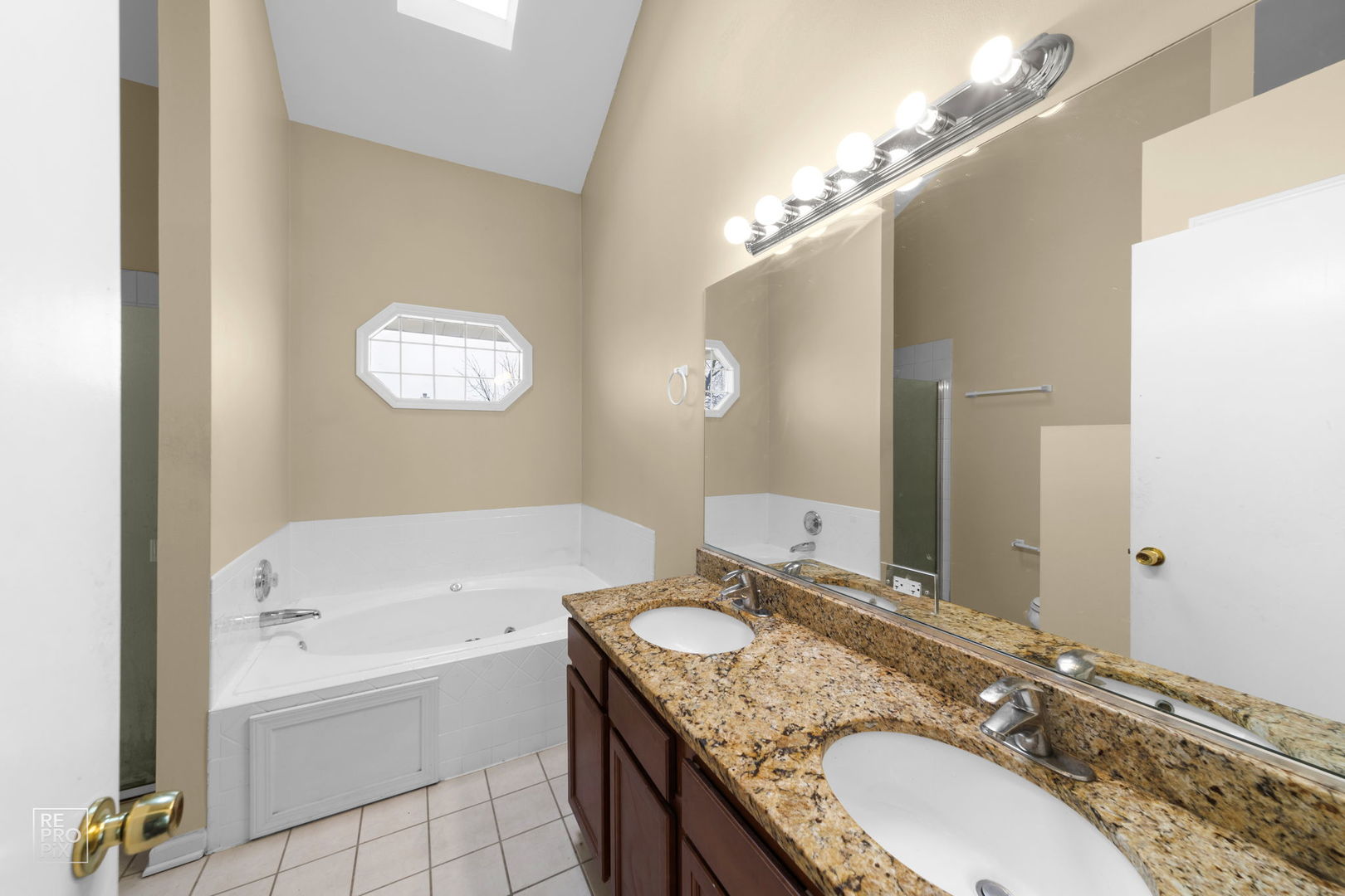 5519 Feather Creek Road Matteson, IL 60443 - Photo 18 of 26 a bathroom with a granite countertop bathtub a sink and a mirror