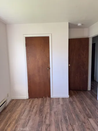 an empty room with wooden floor and closet