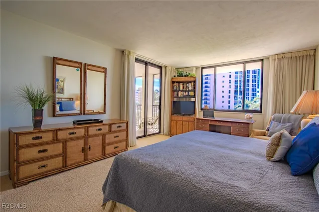 a bedroom with a bed and large windows