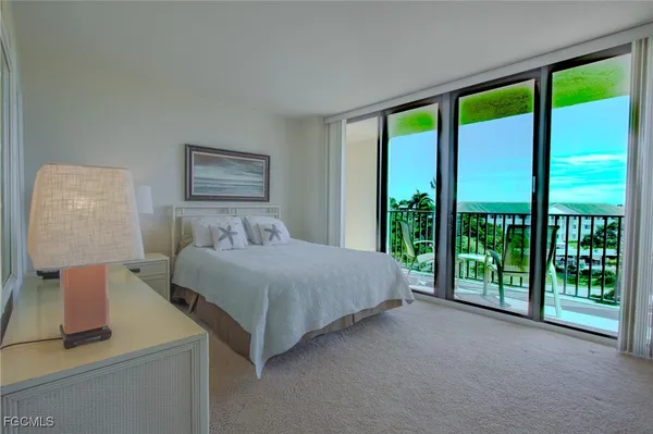 a spacious bedroom with a balcony a bed and a large window