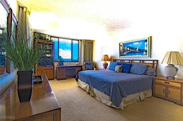 a spacious bedroom with a bed window and table