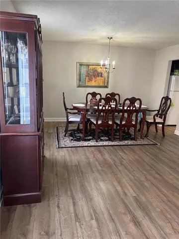 a living room with furniture a chandelier and wooden floor