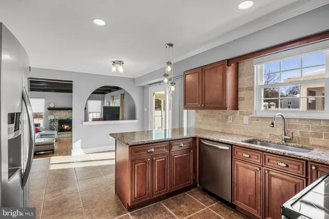a kitchen with granite countertop a sink stove and cabinets