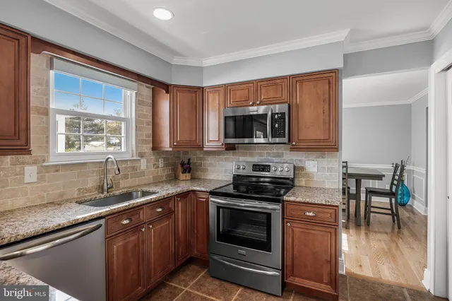 a kitchen with stainless steel appliances a stove sink microwave and cabinets