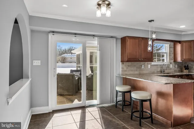 a kitchen with stainless steel appliances granite countertop a refrigerator a stove and a sink with granite countertops