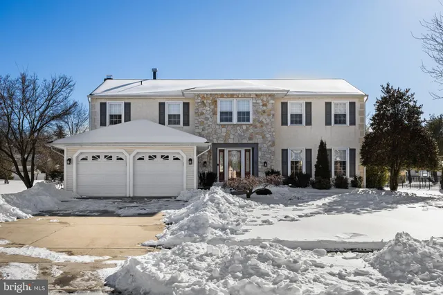 a view of a white house with a snow in the background