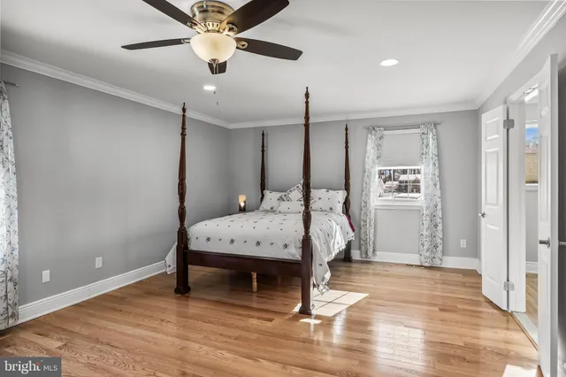 a bedroom with a bed chandelier and a window