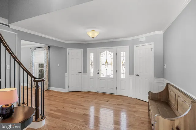 a view of an empty room with wooden floor and furniture