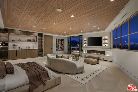 a bedroom with a bed a flat screen tv and balcony