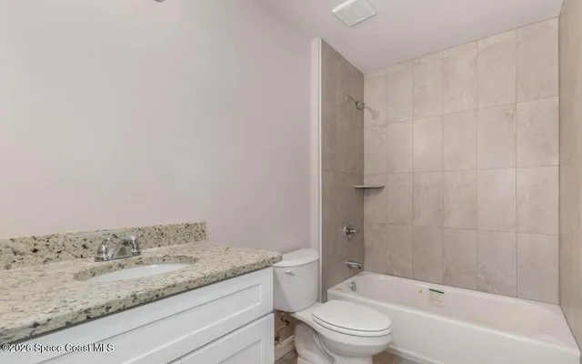 a bathroom with a granite countertop sink toilet and bathtub