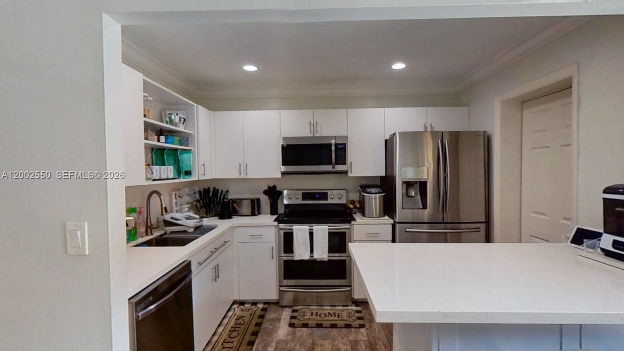 13731 Southwest 84th Street, Unit C11 Miami, FL 33143 - Photo 17 of 32 a kitchen with stainless steel appliances a refrigerator a stove a microwave and cabinets