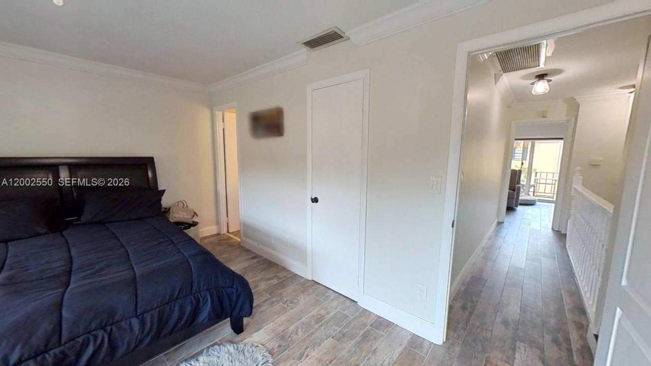 13731 Southwest 84th Street, Unit C11 Miami, FL 33143 - Photo 23 of 32 a bedroom with a bed and wooden floor