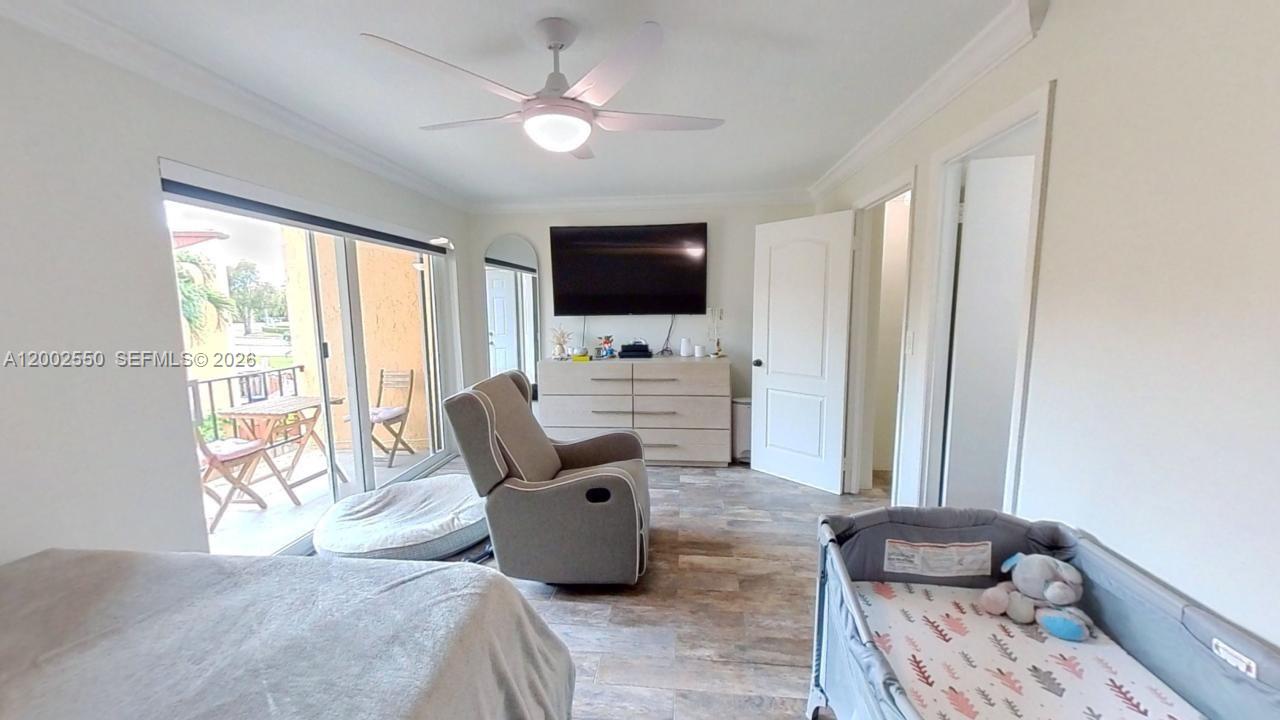 13731 Southwest 84th Street, Unit C11 Miami, FL 33143 - Photo 31 of 32 a bedroom with furniture and a flat screen tv