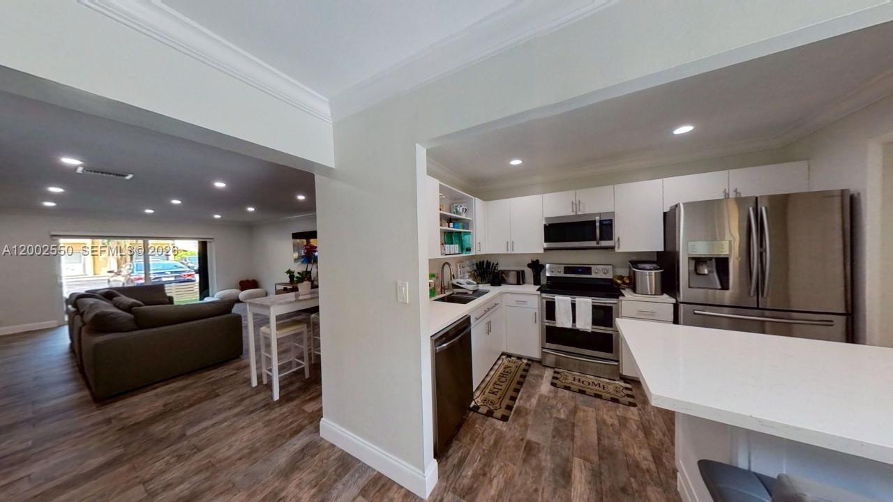 13731 Southwest 84th Street, Unit C11 Miami, FL 33143 - Photo 5 of 32 a living room with stainless steel appliances furniture fireplace and television