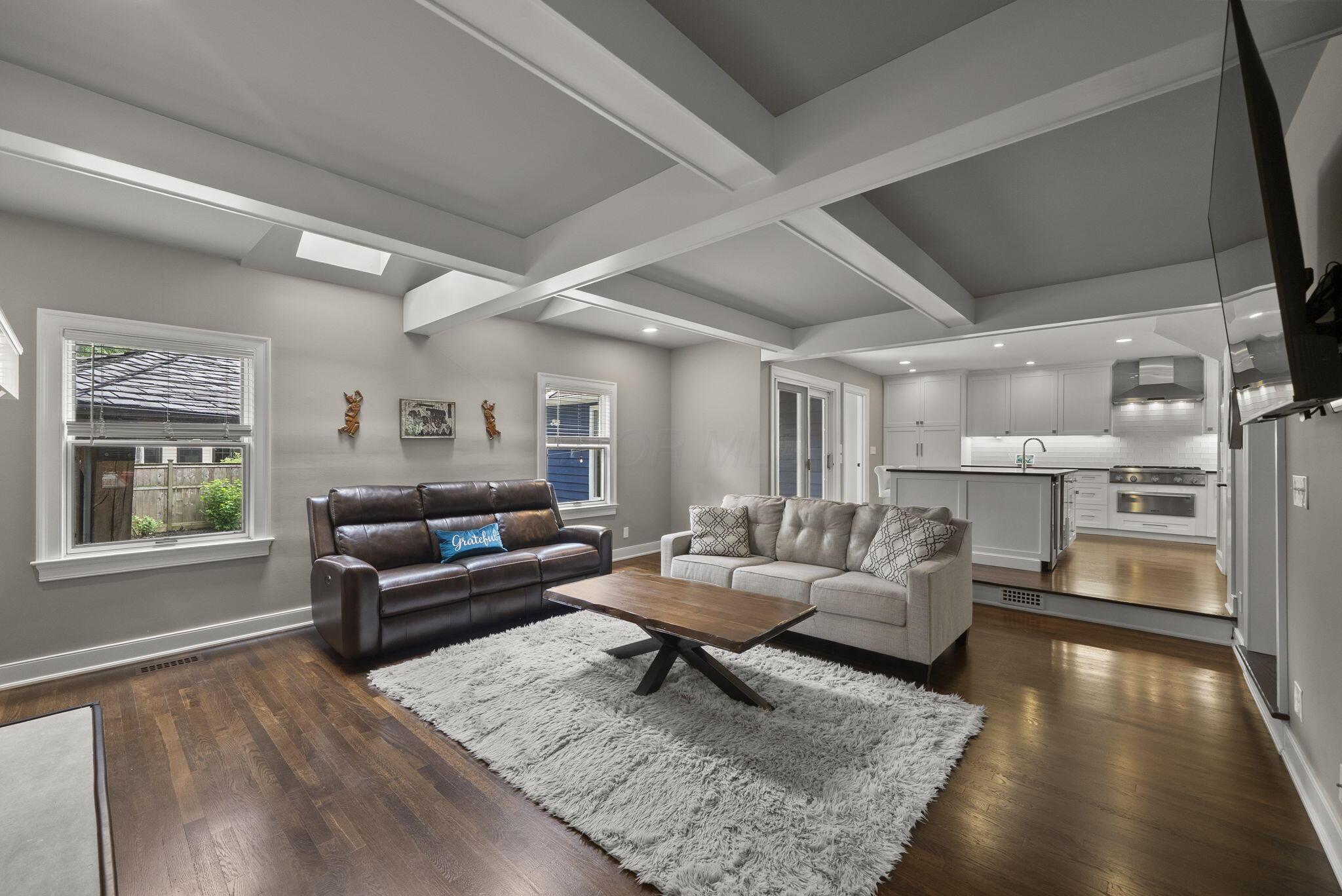 1851 Berkshire Road Columbus, OH 43221 - Photo 21 of 125 Step down family room with elevated coffered ceilings, warm, natural light brightens the room through skylights and warm wood floors.