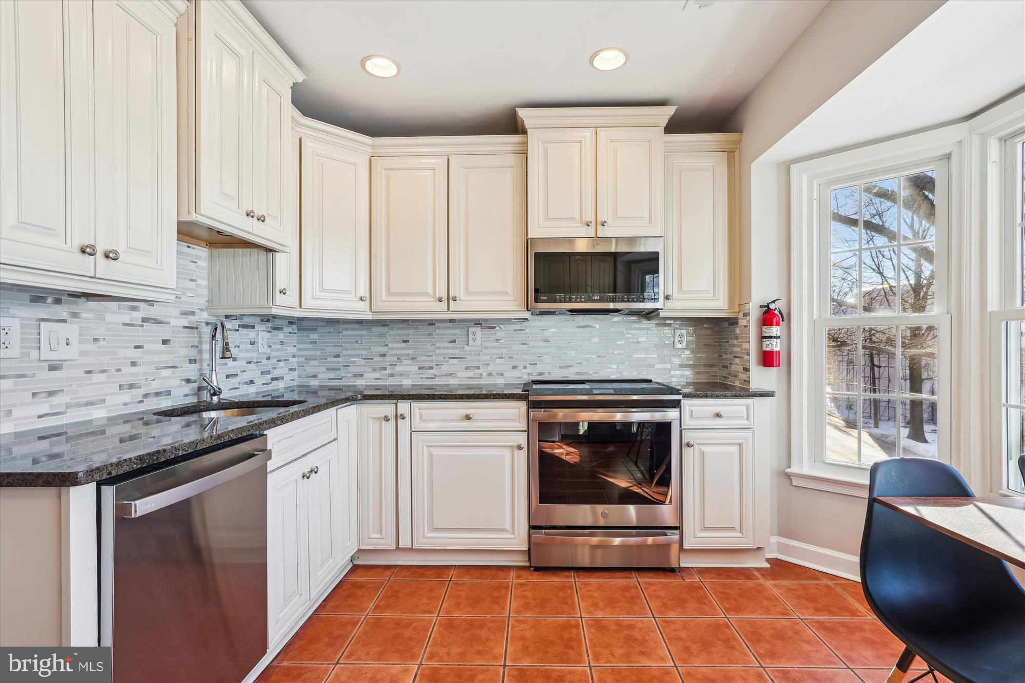 4611 1/2 MacArthur Boulevard Northwest, Unit B Washington, DC 20007 - Photo 13 of 43 a kitchen with stainless steel appliances granite countertop a stove a sink and a microwave
