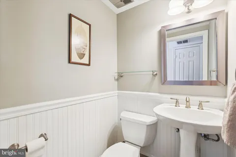 a bathroom with a sink mirror and a toilet
