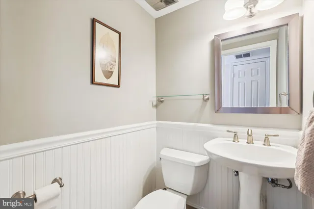 a bathroom with a sink mirror and a toilet