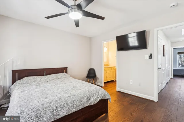 a bedroom with a large bed and a flat tv screen on dresser