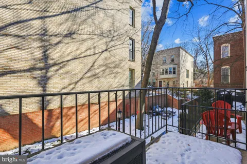 a balcony with wooden floor and outdoor seating