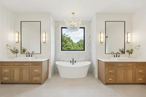 a spacious bathroom with a double vanity sink mirror and bathtub