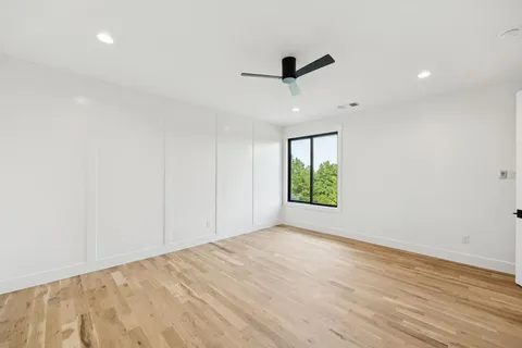 an empty room with a window and a ceiling fan