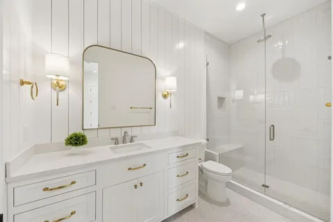 a bathroom with a double vanity sink toilet and shower
