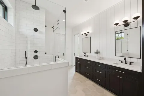 a bathroom with a double vanity sink mirror double and shower