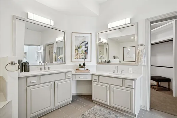 a kitchen with white cabinets sink and stove