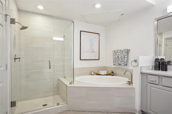 a bathroom with a bathtub shower sink and mirror