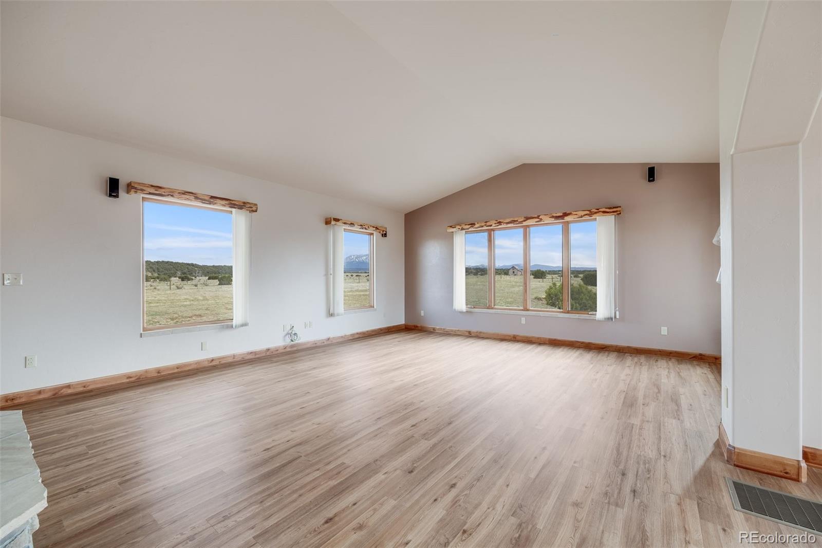 185 River Ridge Trail Walsenburg, CO 81089 - Photo 8 of 50 an empty room with wooden floor and windows