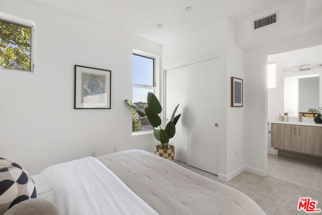 a bedroom with a bed and a potted plant