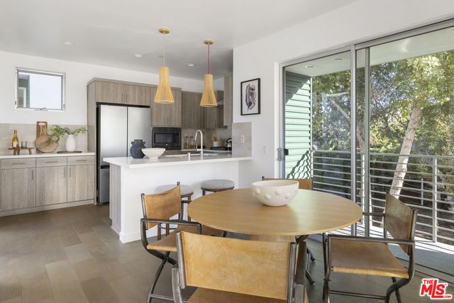 a kitchen with kitchen island a table and chairs in it