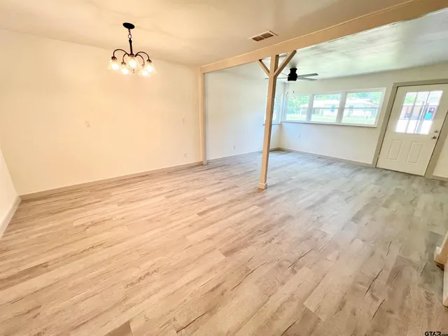 a view of a room with wooden floor and windows