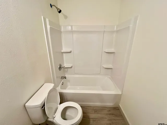 a bathroom with a toilet and a bath tub