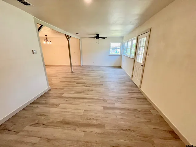 a view of a hallway with wooden floor and entryway