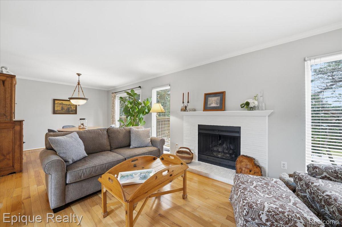 26 Kirks Court Rochester, MI 48309 - Photo 11 of 44 Living space featuring wood-finish flooring and a white-painted brick fireplace with a stone hearth