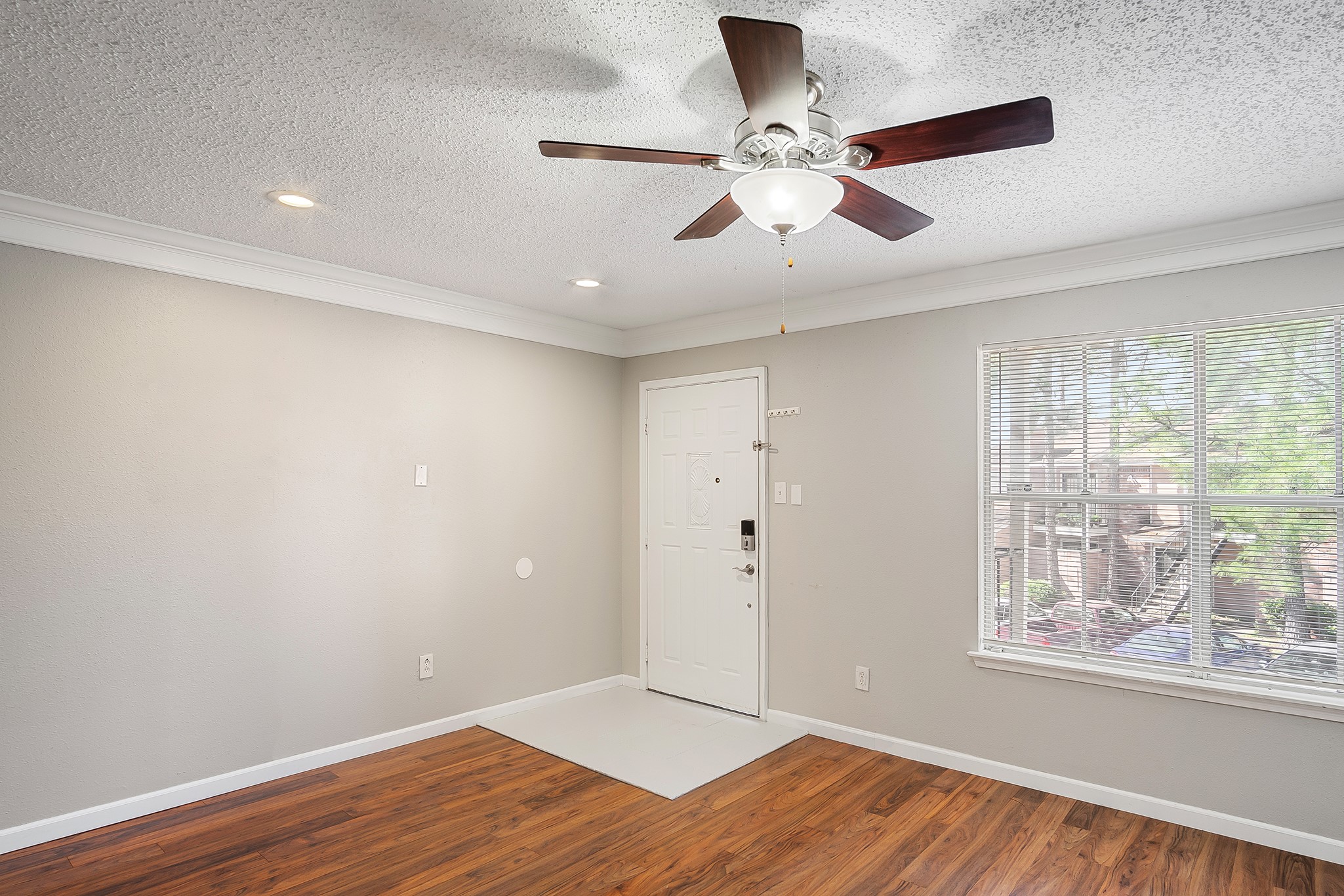 7402 Alabonson Road, Unit 510 Houston, TX 77088 - Photo 2 of 14 a view of an empty room with wooden floor and a window