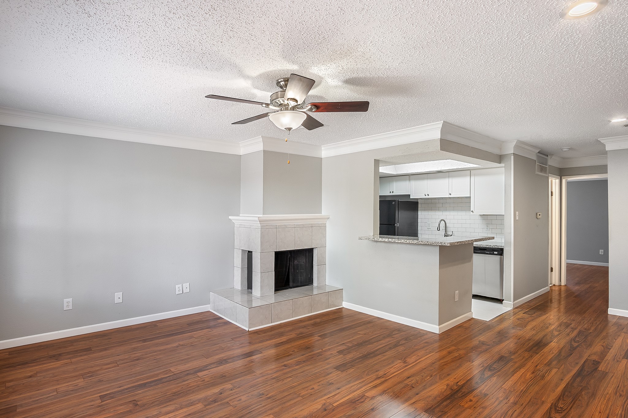 7402 Alabonson Road, Unit 510 Houston, TX 77088 - Photo 4 of 14 a view of an empty room with wooden floor and a kitchen