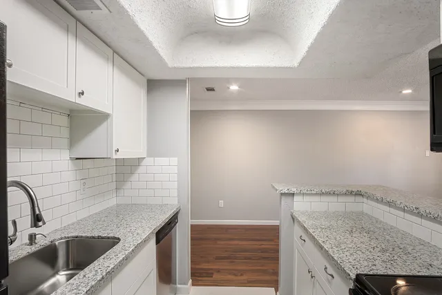a kitchen with granite countertop sink and stove