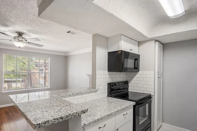 a kitchen with stainless steel appliances granite countertop a sink and a refrigerator