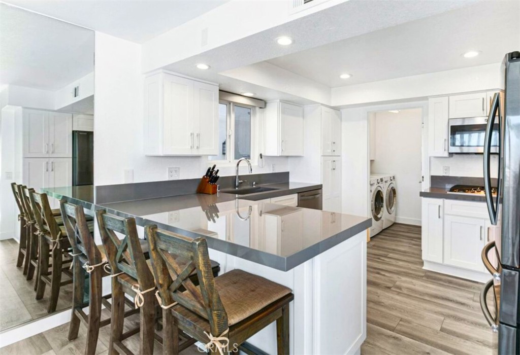 121 Boca De La Playa, Unit 1 San Clemente, CA 92672 - Photo 11 of 47 a kitchen with granite countertop a stove a sink and a refrigerator