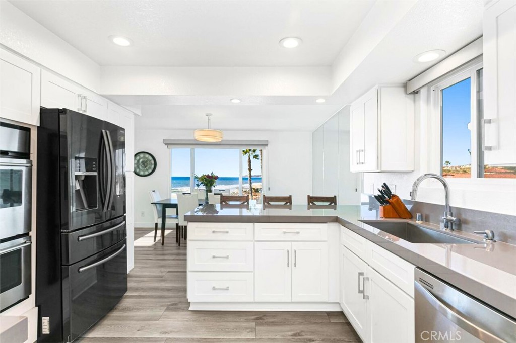 121 Boca De La Playa, Unit 1 San Clemente, CA 92672 - Photo 12 of 47 a kitchen with a refrigerator sink and cabinets